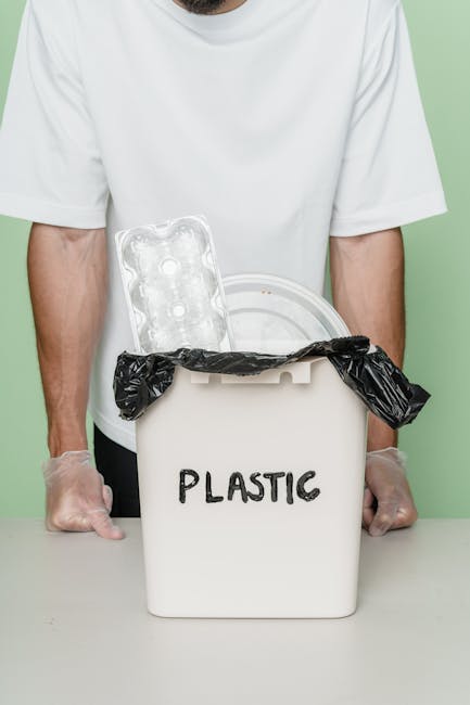 A clear plastic water bottle with a blue cap, partially crushed and showing some dirt and debris on its surface, rests inside a white, woven polypropylene sack that appears to be filled with other waste materials. The sack is open at the top, revealing the bottle among other unidentifiable rubbish. The background consists of a brown, textured outdoor surface, possibly paved or soil, suggesting the scene is set in an external environment suitable for waste collection or disposal. The lighting is natural, casting soft shadows on the bag and the bottle, emphasizing the textures of the plastic and fabric. This image illustrates typical household or commercial waste prepared for rubbish removal, aligning with services such as private rubbish collection or on-site clearance provided by waste removal specialists like Waste Clearance Harringay, highlighting the type of recyclable or general waste often handled through alternative waste handling options rather than council collections.